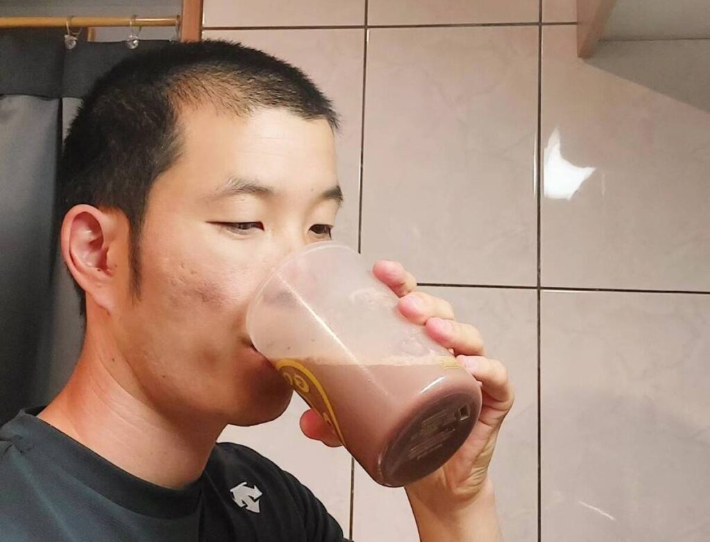 炭酸水を混ぜたプロテインを飲む男性